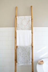 a wooden towel rack in a bathroom next to a toilet