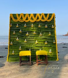 two yellow chairs sitting in front of a green wall