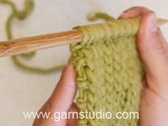 someone is knitting the yarn with a wooden needle