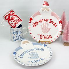 two christmas plates, one with a hand print and the other has a cookie for santa on it