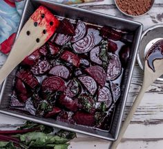 there are many different foods in the pans on the table, including broccoli and beets