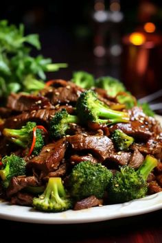 beef and broccoli on a white plate with chopsticks next to it