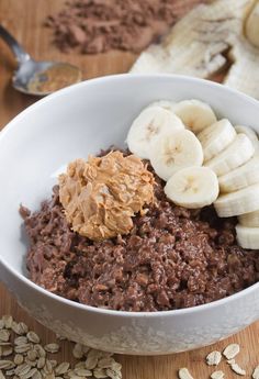 a bowl filled with oatmeal and bananas on top of a wooden table