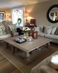 a living room filled with lots of furniture and pillows on top of a wooden table