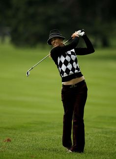 a woman in black and white shirt playing golf