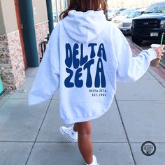 ★ Delta Zeta Sweatshirt: Comfort and Style ★  Many Sweatshirt colors to choose from!! Stay warm and cozy in our Delta Zeta hooded sweatshirt. This unisex heavy blend sweatshirt is perfect for chilly days and casual outings. Made with a soft and durable blend of cotton and polyester, it offers ultimate comfort and style. ★ SIZING ★ Unisex and true-to-size. Measurements are the same for the hoodie and crewneck. See size chart in listing photos for exact measurements. - FOR AN OVERSIZED LOOK: We recommend sizing up - FOR A FITTED LOOK: We recommend getting your usual size. ★ Key Features ★  Plush and warm: Made with a medium-heavy fabric blend for maximum comfort. Spacious kangaroo pocket: Convenient for storing essentials. Color-matched drawstring: Adds a touch of style. Tear-away label: No Delta Zeta Necklace, Delta Zeta Merch, Sweatshirt Colors, Sorority Shirt, Letter Hoodie, Chair Ideas, Delta Zeta