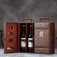 two bottles of wine in an open leather case next to a corkscrew box