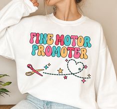 a woman wearing a white shirt that says fine motor promoter