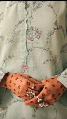 a close up of a person's hands with rings on them