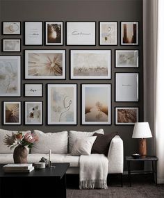 a living room filled with lots of pictures on the wall above a white couch and coffee table