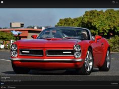 a red car is driving down the street