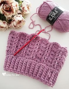 a crochet project with yarn and knitting needles