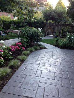 a walkway in the middle of a garden with pink and white flowers on either side