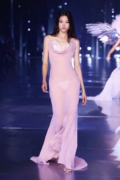 a model walks down the runway in a pink dress with angel wings on it's shoulders