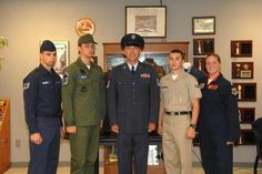 four people in uniform standing next to each other