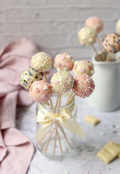 some cake pops are in a glass vase