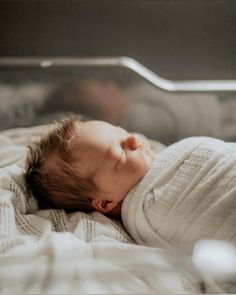 a baby is sleeping on a blanket in the crib with his head tucked up