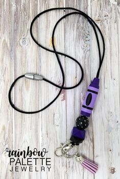 a purple and black lanyard on a white wooden background with the words rainbow palette jewelry