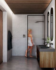 a woman standing in front of a shower next to a sink