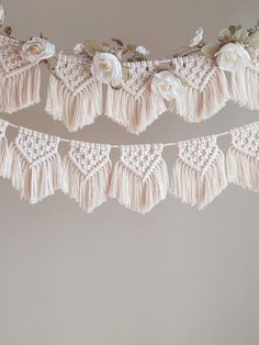 there is a white crochet and tasseled garland hanging from the ceiling