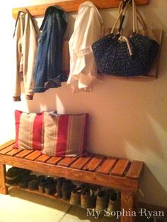 a wooden bench with shoes and bags hanging on it's wall next to a coat rack