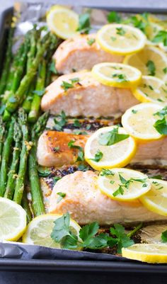 salmon and asparagus on a sheet pan with lemons