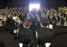 a band playing in front of an audience at night