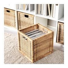 a wicker basket sitting on the floor in front of bookshelves