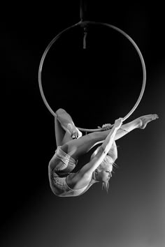 a woman is doing tricks on a hoop