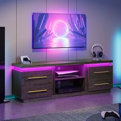 the entertainment center is lit up with purple lights and headphones on it's sides