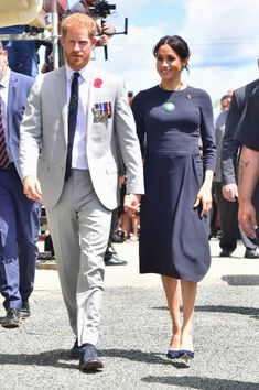 prince harry and his wife, the duke of cambridge, are seen walking in front of photographers