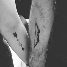 two people holding hands with tattoos on their arms and one has an arrow in the middle