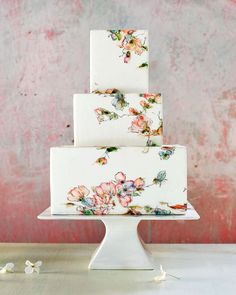 a three tiered cake with flowers painted on it