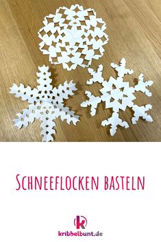 some white paper snowflakes on top of a wooden table with the words schneflocken basteln