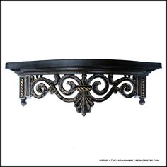 an ornate metal shelf with black paint and decorative designs on the top, against a white background