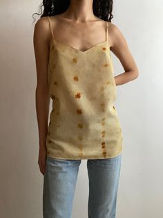 Vintage silk camisole, hand dyed with chestnut and coreopsis flowers from my garden in New Mexico. BRAND: Fashion Options (reworked vintage) MATERIAL: 100% silk    SIZE:  Marked: 16 Measurements:  Pit to pit- 19.75" Length- 17.75" Figure is an XS/S and measures 5'4", 30" bust, 24" waist, 33" hips.   **Too big on figure. Pinned in first photo to give an idea of fit.** CARE: Hand wash separately with cold water and gentle, natural, ph-neutral soap. Air-dry away from direct sunlight. NATURAL VARIATIONS, MARKS, & CHANGES: Colors and shades are shown to the best of our ability, however there will be variations from batch to batch. Due to the nature of plant dyeing, each piece is unique and may have subtle marks or specks from dye flowers, leaves, roots, and more, adding to the beauty of natural Hand Dyed Sleeveless Top For Spring, Hand Dyed Yellow Top For Summer, Hand Dyed Yellow Tops For Summer, Yellow Hand-dyed Top For Summer, Summer Yellow Hand-dyed Top, Summer Hand-dyed Yellow Top, Spring Hand Dyed Tie Dye Tank Top, Spring Hand-dyed Tie Dye Tank Top, Hand Dyed Tie Dye Tank Top For Spring