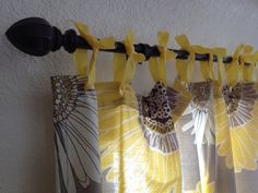 yellow and white curtains hanging on the side of a wall