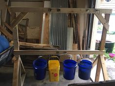 three buckets sitting next to each other in a garage