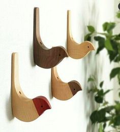 three wooden birds are hanging on the wall