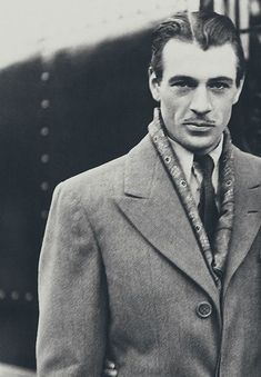 a man in a suit and tie standing next to an airplane