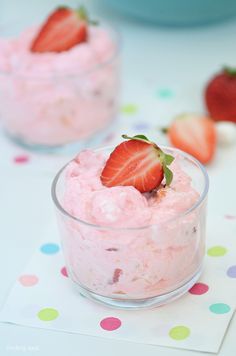 two small bowls filled with food on top of a polka dot table cloth next to strawberries