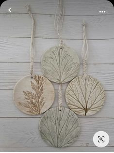 three wooden ornaments hanging on a wall with string attached to the back of each ornament