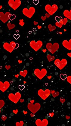 many red hearts floating in the air on a black background with sparkles and confetti