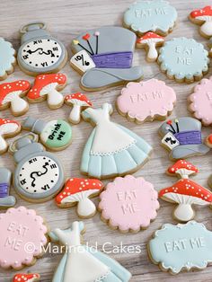 decorated cookies are arranged on a table with the words eat me written in different languages