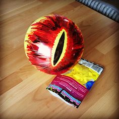 an orange ball laying on top of a wooden floor next to a bag of candy