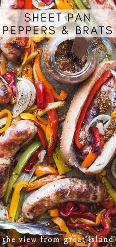 a sheet pan filled with peppers and bratwursts on top of a table