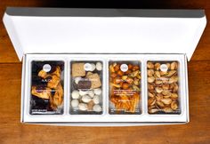 an open white box containing nuts on a wooden table