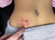 a hello kitty tattoo on the side of a woman's stomach is being shown