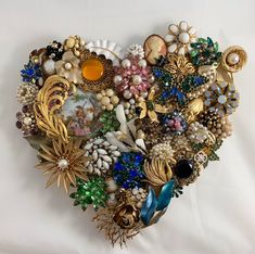 a heart shaped brooch with many different types of buttons