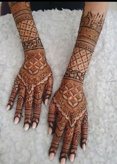 two hands with henna tattoos on them